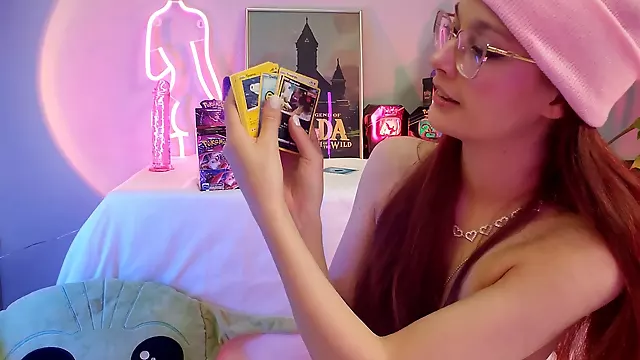 Naughty nerdy fuck doll reveals her small tits while showing off her Pok mon card collection